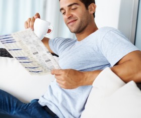 Man sitting on sofa reading morning newspaper Stock Photo