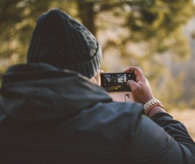 Man using mobile phone to shoot landscape Stock Photo
