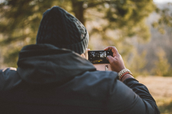 Man using mobile phone to shoot landscape Stock Photo