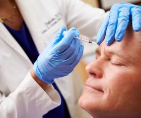 Middle-aged male facial botox injection Stock Photo