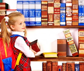 Pupil holding a heavy book Stock Photo