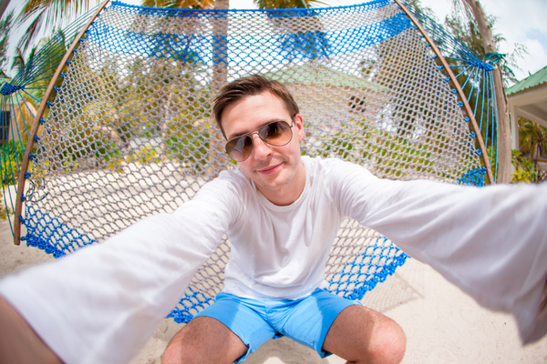 Sitting on hammock men selfie Stock Photo