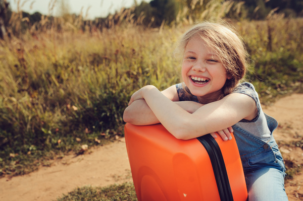 Smiling little girl and luggage Stock Photo