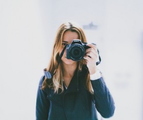 Woman holding camera to take picture Stock Photo