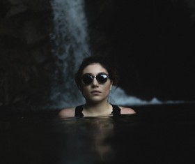 Woman swimming on stream with sunglasses Stock Photo