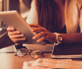 Woman using Tablet PC to check flights Stock Photo
