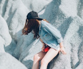 Young attractive woman on white stones cliff Stock Photo