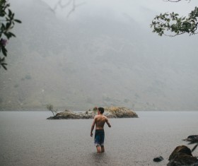 Young man playful on lake in rain Stock Photo