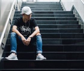 Young people sitting alone on the stairs Stock Photo