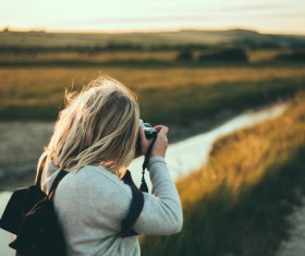 blonde girl enjoying rural scene with camera Stock Photo