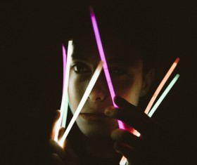 man playful with bright sticks in darkness Stock Photo