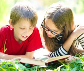 Children reading books on the grass Stock Photo
