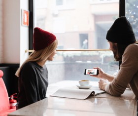 Couple sitting in cafe watching smartphone taking photo Stock Photo 01