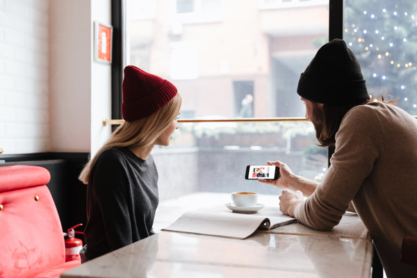 Couple sitting in cafe watching smartphone taking photo Stock Photo 01