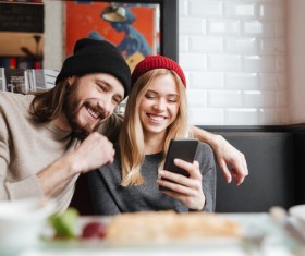 Couple sitting in cafe watching smartphone taking photo Stock Photo 04