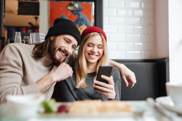 Couple sitting in cafe watching smartphone taking photo Stock Photo 04