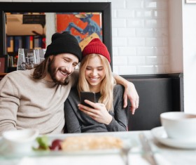 Couple sitting in cafe watching smartphone taking photo Stock Photo 06