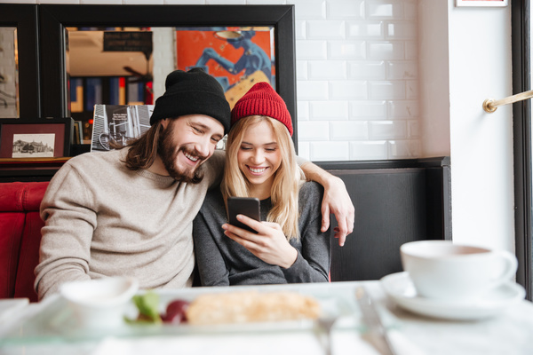 Couple sitting in cafe watching smartphone taking photo Stock Photo 06