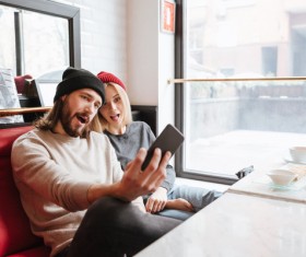 Couple using smartphone selfie in cafe Stock Photo 01
