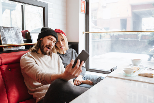 Couple using smartphone selfie in cafe Stock Photo 01