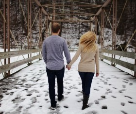 Couple walking hand in hand on the snow Stock Photo