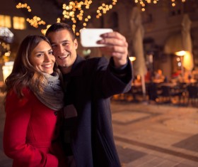 Couples using smartphone selfie on street Stock Photo