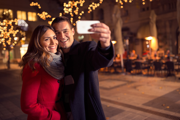 Couples using smartphone selfie on street Stock Photo