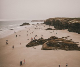 Crowded people gathering on rocky seaside Stock Photo