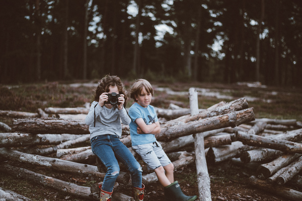 Cute young boys sitting on tree trunks Stock Photo