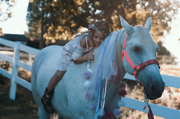 Cute young girl posing on horse back Stock Photo