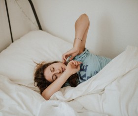 Cute young woman relaxing on bed Stock Photo