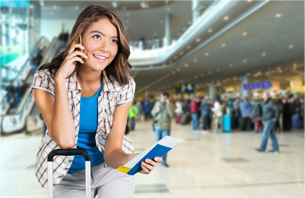 Girl is phoning in airport waiting room Stock Photo