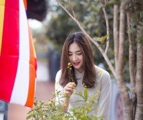 Girl looking at yellow flowers Stock Photo