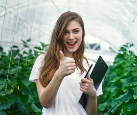 Girl with thumbs up in hothouse Stock Photo