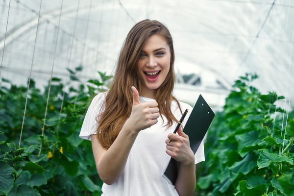 Girl with thumbs up in hothouse Stock Photo