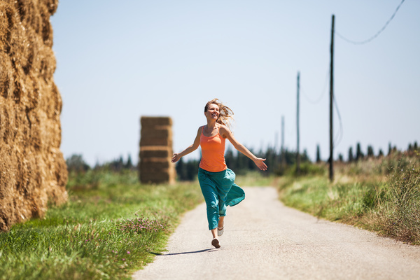 Happy girl running on the road Stock Photo