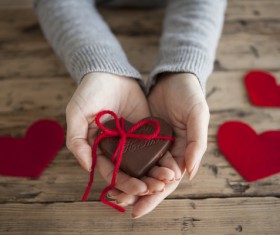 Heart shaped chocolate candy in woman hand Stock Photo