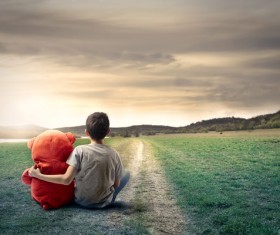Little boy and toy sit on the road Stock Photo