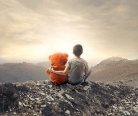 Little boy and toy sitting on the hill Stock Photo