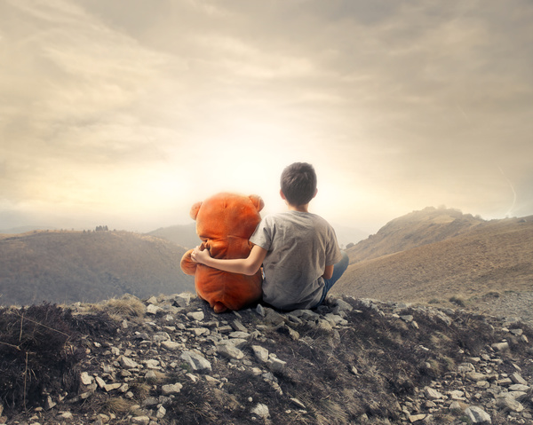 Little boy and toy sitting on the hill Stock Photo