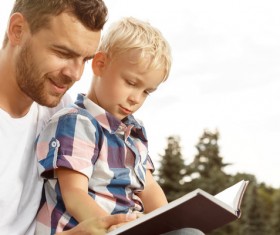 Little boy reading book with dad Stock Photo