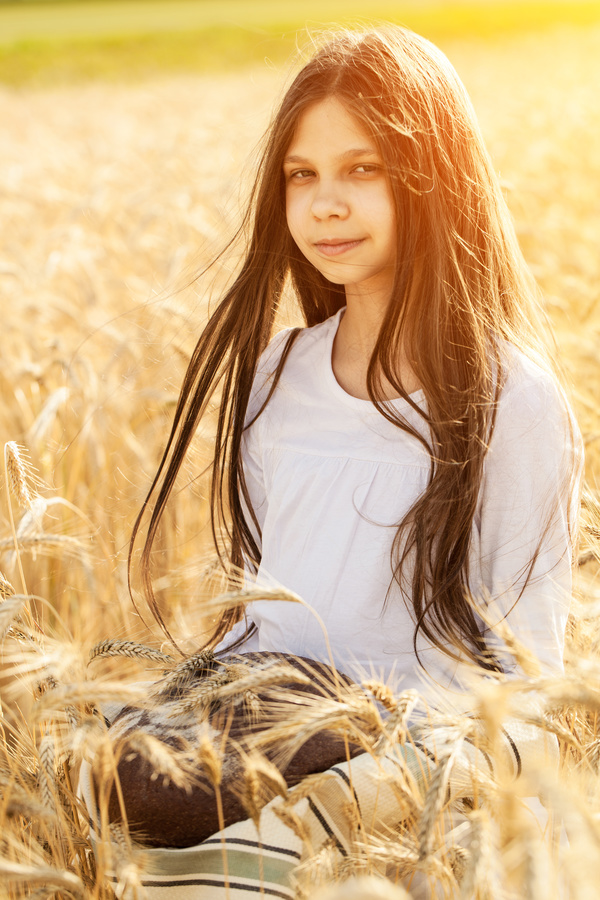Little girl holding bread in wheat field Stock Photo 02