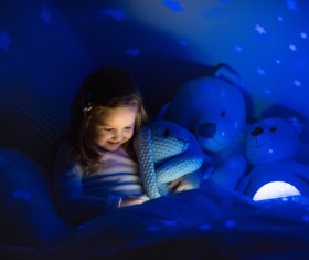 Little girl reading a book at night Stock Photo