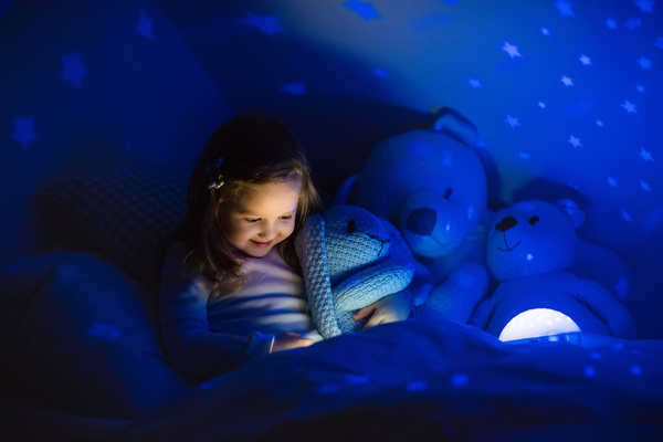 Little girl reading a book at night Stock Photo