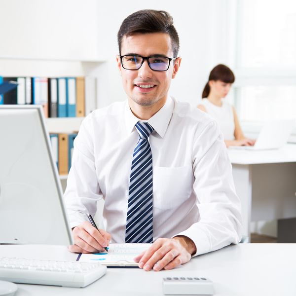 Male salesman sitting in front of computer Stock Photo