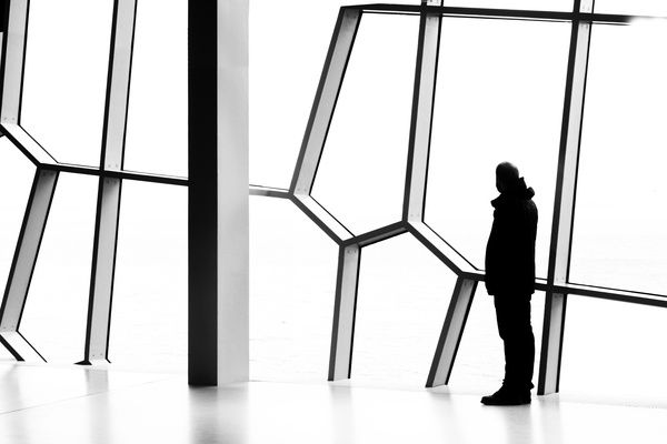 Man standing in front of geometric window Stock Photo