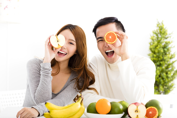 Men and women holding fruits Stock Photo
