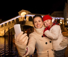 Mother holding children using smartphone selfie Stock Photo