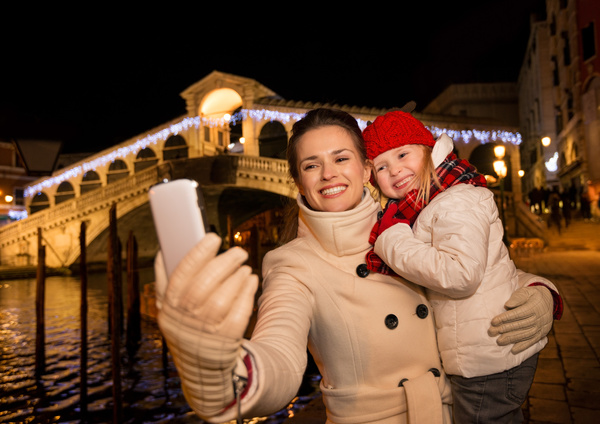Mother holding children using smartphone selfie Stock Photo