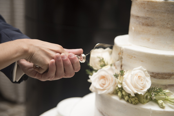 Newly-married couple cutting cake Stock Photo